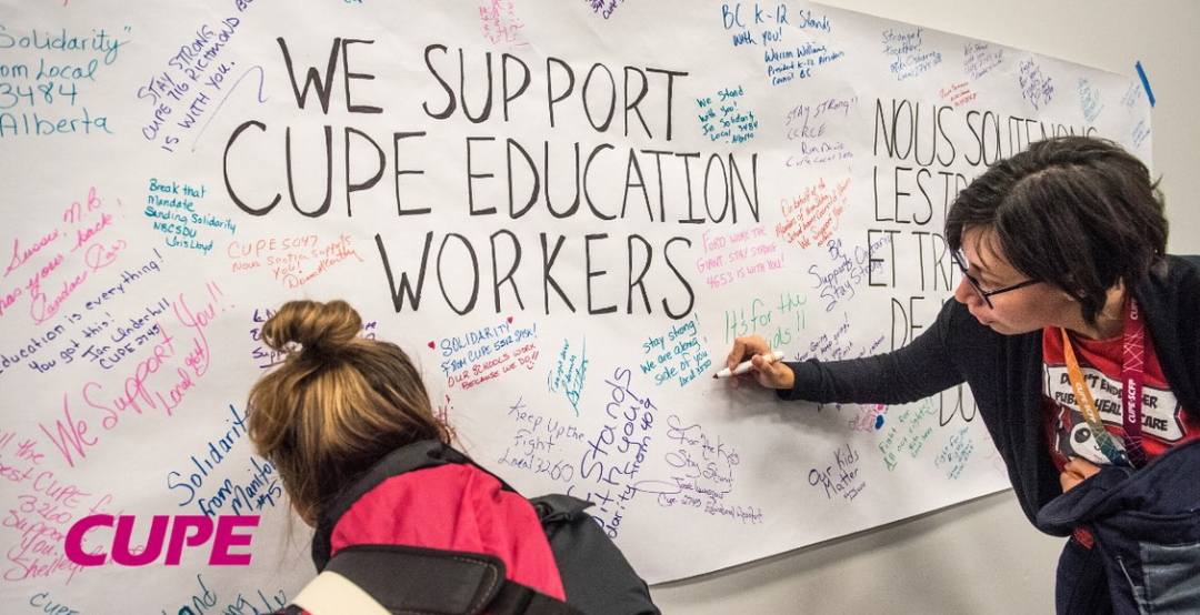 Image of two people writing on chart paper affixed to a wall; the main text reads, "We Support CUPE Education Workers."